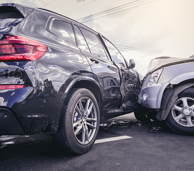 a silver car crashed into the front right-hand door of a black car